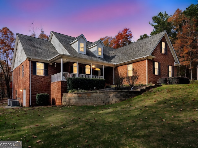 cape cod-style house with cooling unit and a yard