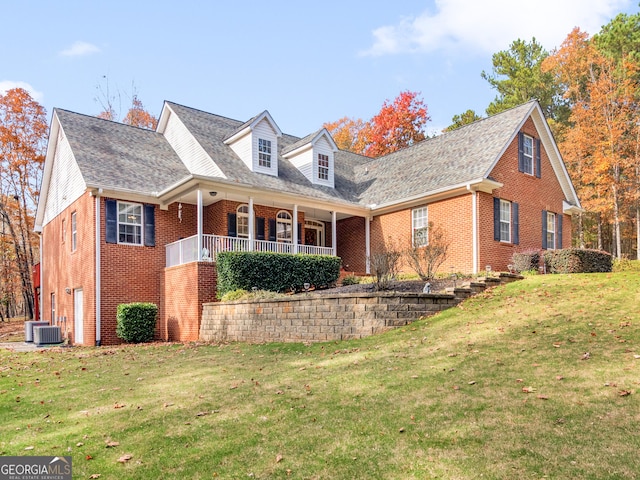 cape cod-style house with central AC unit, a front yard, and covered porch