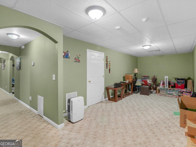 basement with carpet flooring and a paneled ceiling