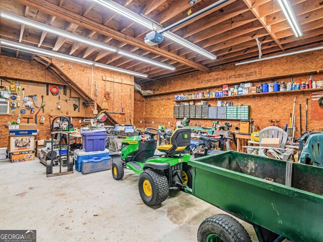 misc room with a workshop area, electric panel, and concrete floors