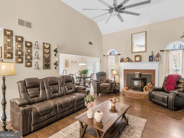 living room with a towering ceiling, hardwood / wood-style flooring, and ceiling fan