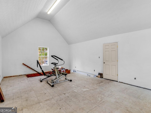 workout room featuring lofted ceiling and a textured ceiling