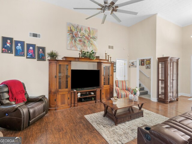 living room featuring a chandelier, a towering ceiling, dark hardwood / wood-style floors, and sink