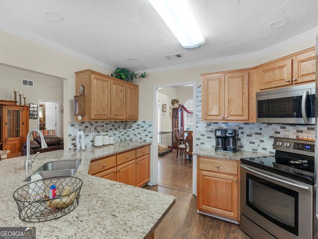 kitchen with backsplash, sink, ornamental molding, dark hardwood / wood-style flooring, and light stone counters