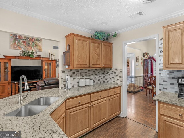 kitchen with dishwasher, tasteful backsplash, crown molding, and sink