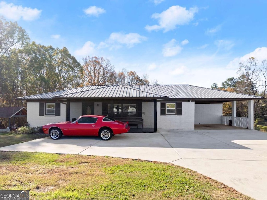 ranch-style house featuring a front lawn and a carport