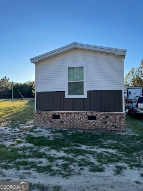 view of side of home with a yard