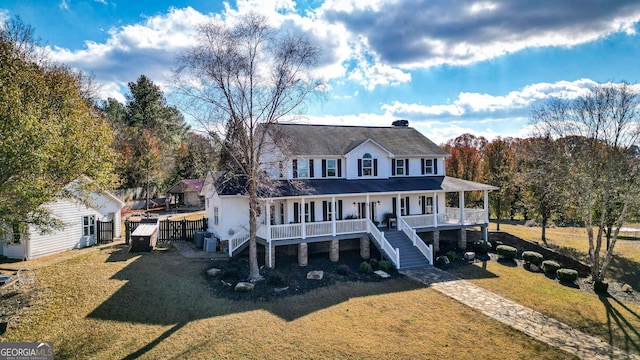 view of front of house featuring covered porch, a front lawn, and central air condition unit