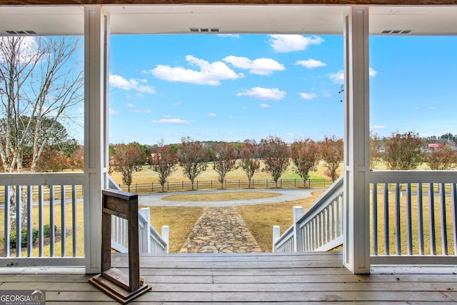 deck featuring a yard and a rural view