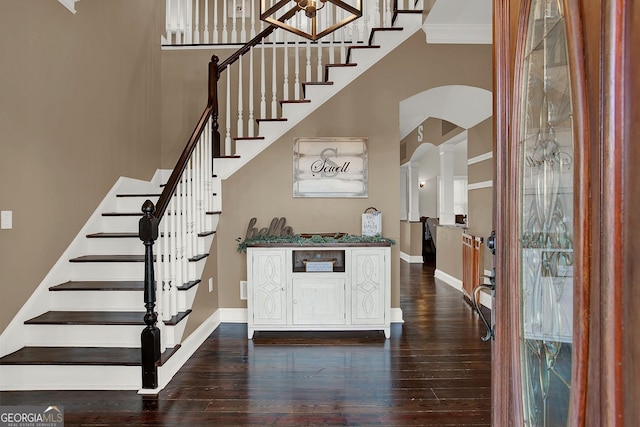 entryway with dark hardwood / wood-style floors and crown molding