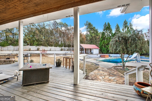 deck with a fenced in pool and exterior bar