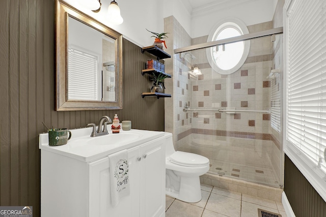 bathroom with tile patterned flooring, vanity, toilet, and a shower with door