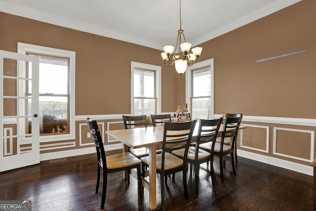 dining area featuring a notable chandelier, crown molding, and dark wood-type flooring