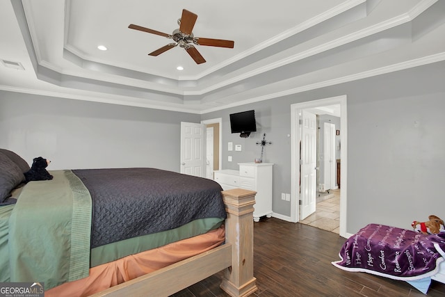 bedroom with a tray ceiling, crown molding, ceiling fan, and dark wood-type flooring