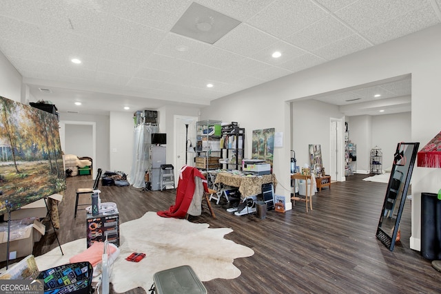 workout room featuring a paneled ceiling and dark hardwood / wood-style floors