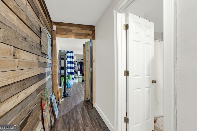 hallway featuring dark hardwood / wood-style floors and wood walls