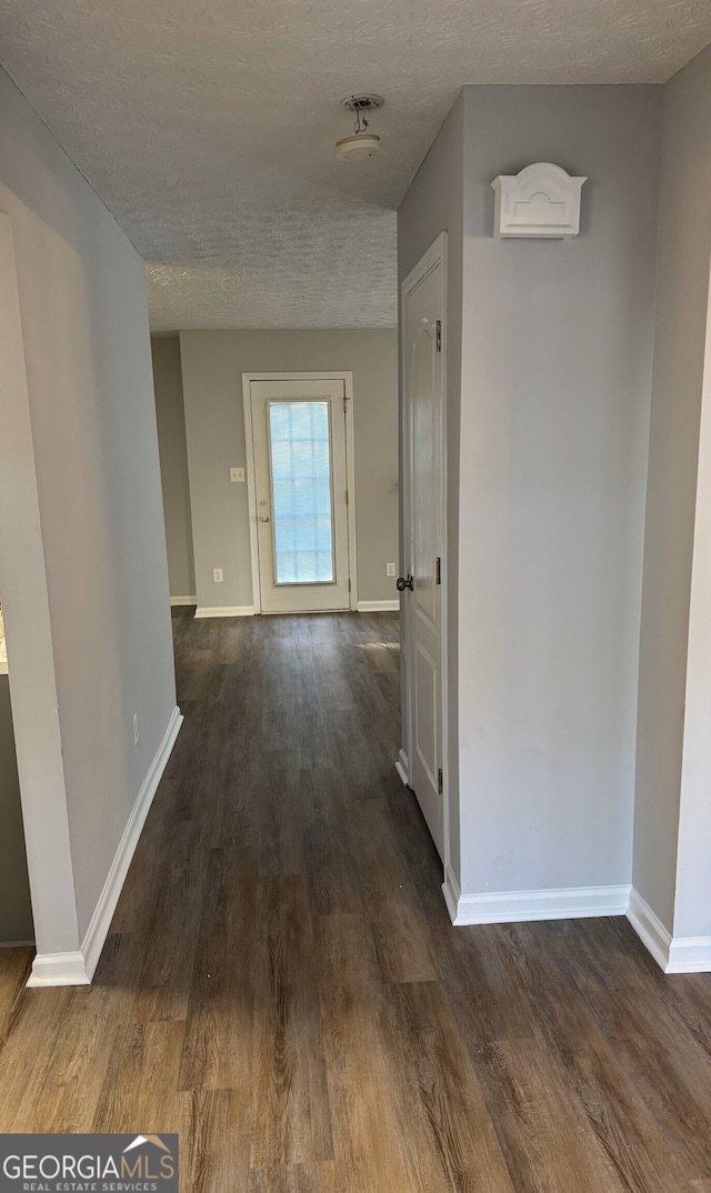 corridor featuring dark hardwood / wood-style floors and a textured ceiling