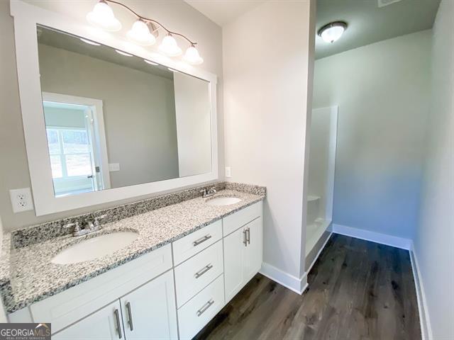 bathroom featuring vanity, hardwood / wood-style flooring, and walk in shower