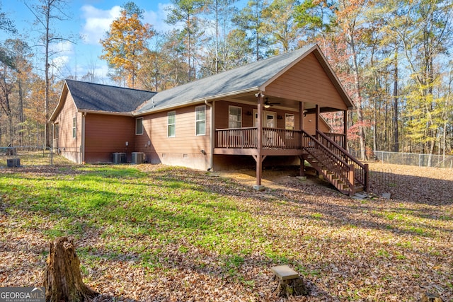 rear view of house featuring central AC, ceiling fan, a yard, and a deck