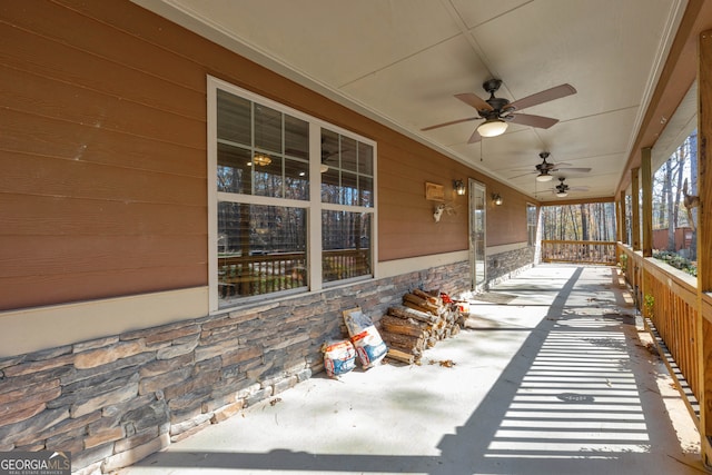 snow covered patio featuring a porch and ceiling fan