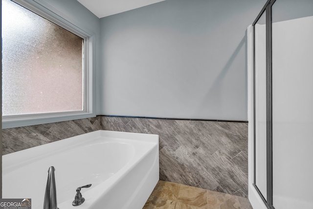 bathroom featuring tile walls and a bathing tub