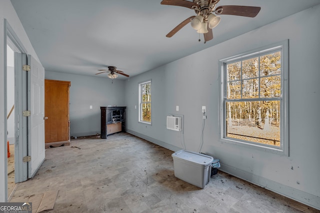 interior space featuring a wall unit AC, plenty of natural light, and ceiling fan