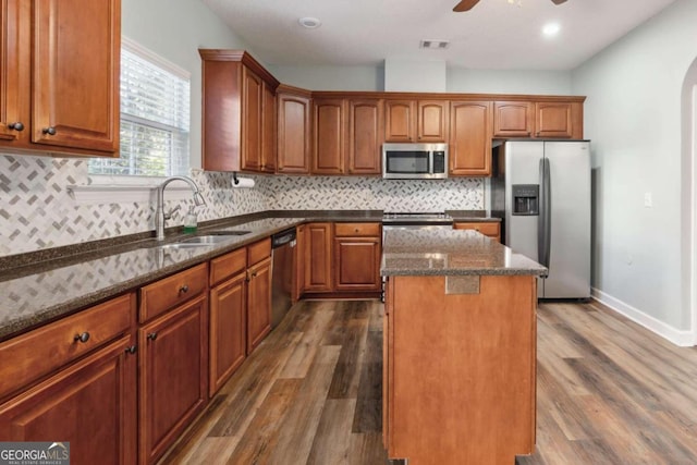 kitchen featuring dark hardwood / wood-style floors, a center island, sink, and stainless steel appliances