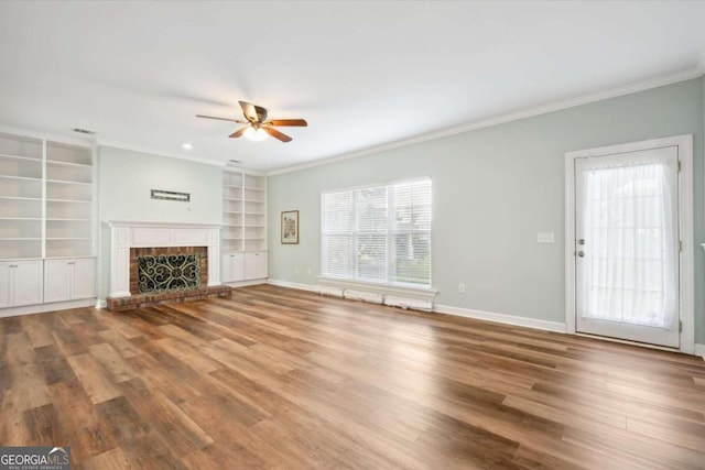 unfurnished living room with a fireplace, hardwood / wood-style flooring, ceiling fan, and ornamental molding