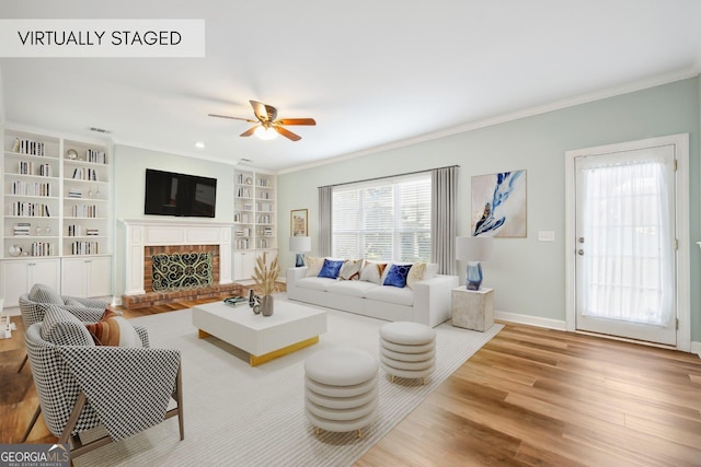 living room with a fireplace, ceiling fan, hardwood / wood-style floors, and crown molding