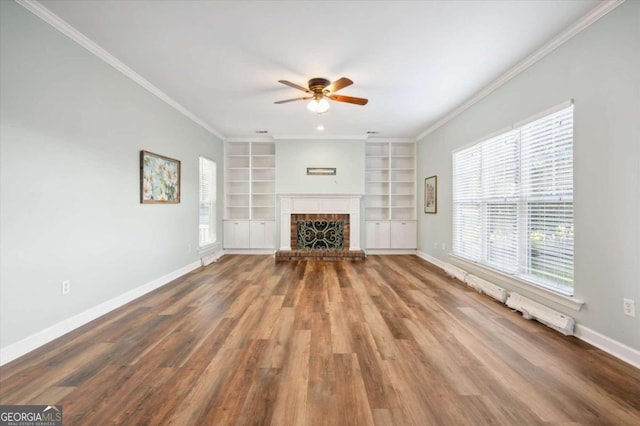 unfurnished living room with hardwood / wood-style floors, a brick fireplace, ceiling fan, and ornamental molding