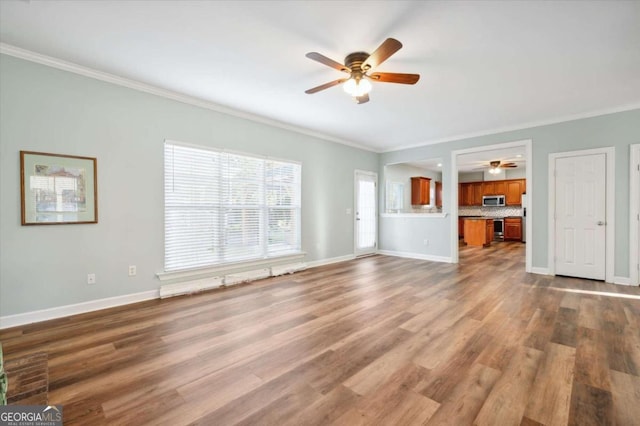 unfurnished living room featuring wood-type flooring, ceiling fan, and ornamental molding