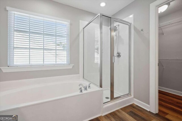 bathroom featuring hardwood / wood-style floors, shower with separate bathtub, and a wealth of natural light