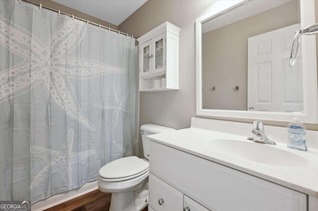 bathroom featuring a shower with shower curtain, vanity, hardwood / wood-style flooring, and toilet