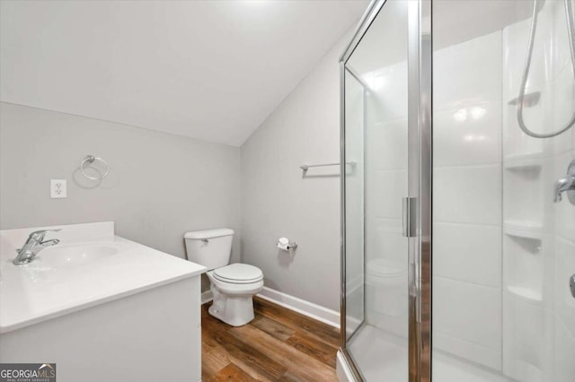 bathroom featuring toilet, hardwood / wood-style floors, lofted ceiling, and walk in shower