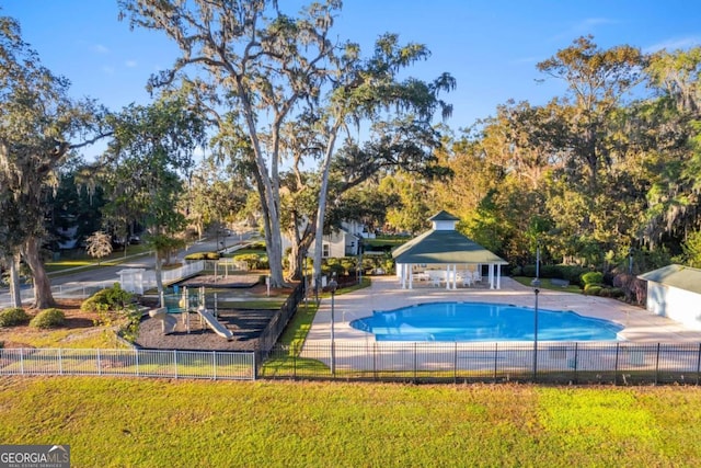 view of swimming pool featuring a gazebo, a playground, and a yard