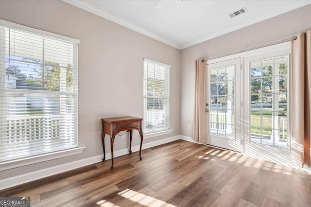 doorway to outside featuring hardwood / wood-style floors, a healthy amount of sunlight, and ornamental molding