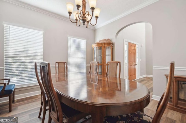 dining space featuring a chandelier, hardwood / wood-style floors, and crown molding