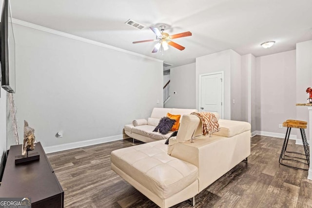 living room featuring ceiling fan, crown molding, and dark wood-type flooring