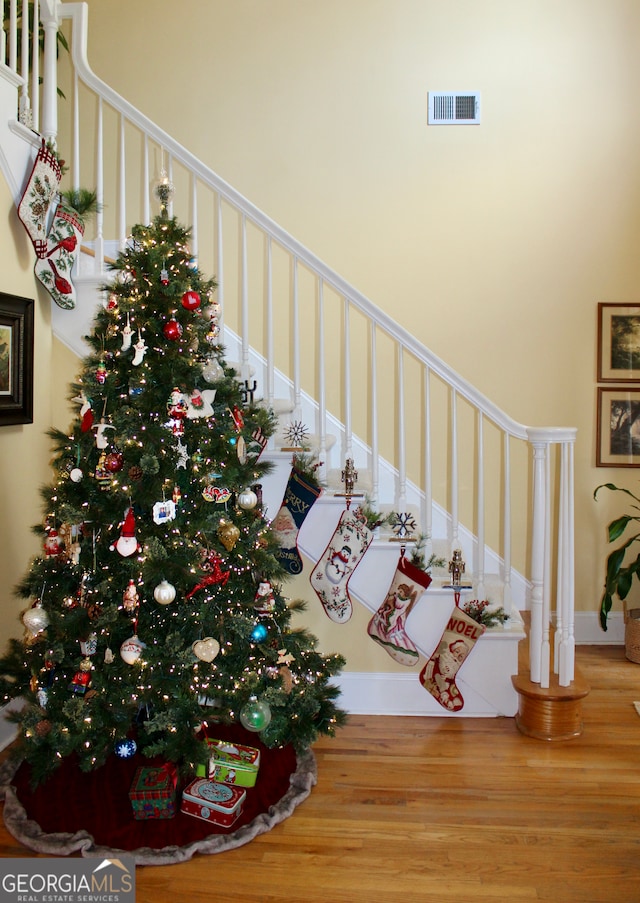 stairway featuring a high ceiling and hardwood / wood-style flooring