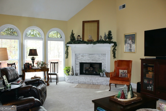 living room with carpet flooring, high vaulted ceiling, and a brick fireplace