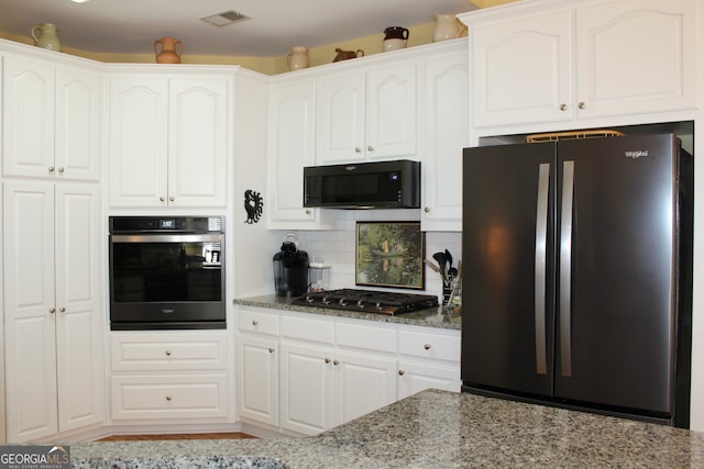 kitchen with backsplash, stainless steel appliances, white cabinetry, and stone countertops