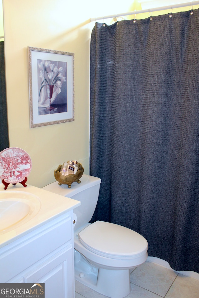 bathroom with walk in shower, tile patterned flooring, vanity, and toilet