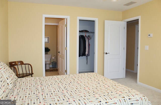 carpeted bedroom featuring a walk in closet, ensuite bath, and a closet