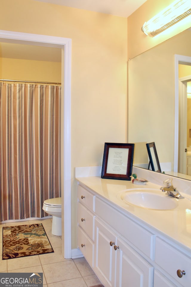 bathroom featuring tile patterned floors, vanity, and toilet