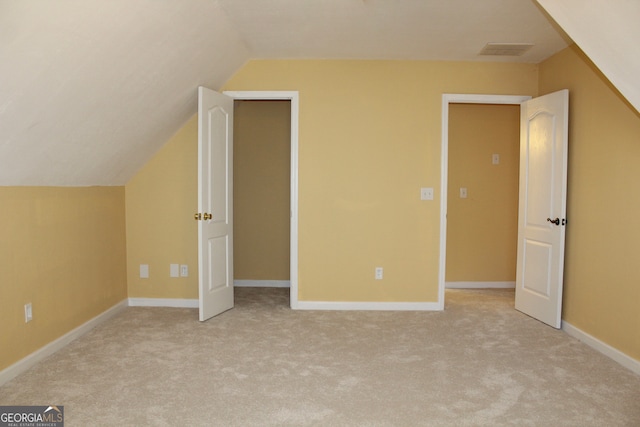 additional living space featuring lofted ceiling and light carpet