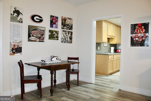 dining space with light hardwood / wood-style flooring and sink