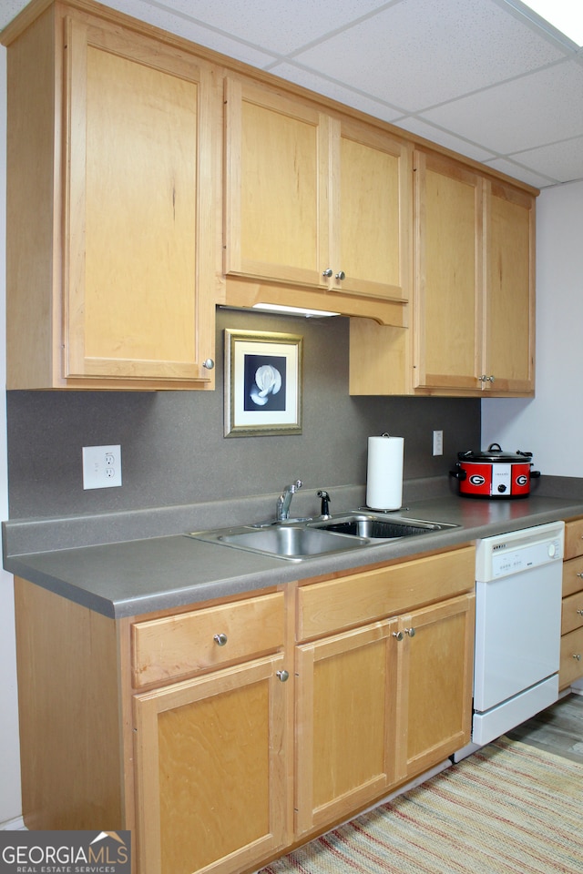 kitchen featuring white dishwasher, a paneled ceiling, sink, and light brown cabinetry