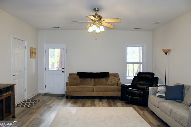 living room featuring dark hardwood / wood-style flooring, ceiling fan, and plenty of natural light