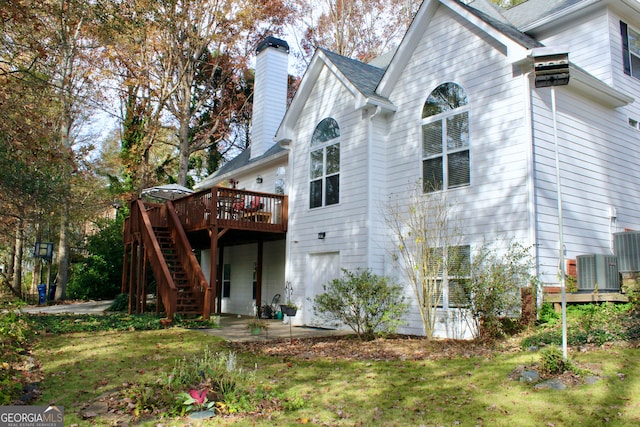 back of property with a deck and a lawn