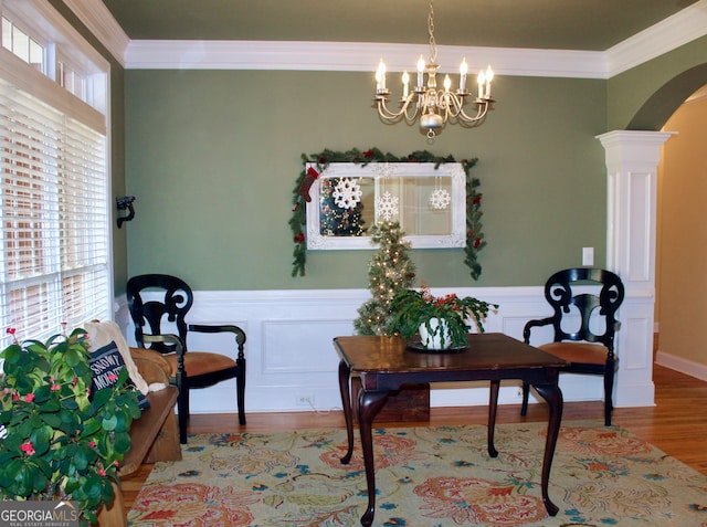 sitting room featuring decorative columns, a healthy amount of sunlight, and ornamental molding